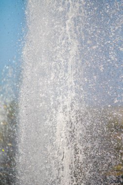 Mavi gökyüzüne karşı Su Çeşmesi sprey. Su sıçramaları odak dışında.