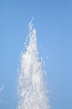 Mavi gökyüzüne karşı Su Çeşmesi sprey. Su sıçramaları odak dışında.