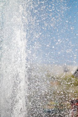 Mavi gökyüzüne karşı Su Çeşmesi sprey. Su sıçramaları odak dışında.
