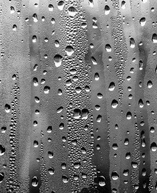 Cam üzerinde yağmur damlaları, siyah-beyaz arka plan, moda cam doku.