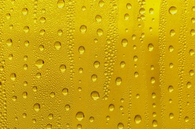 Cam su damlaları, sarı arka plan bira, buğulu arka plan.