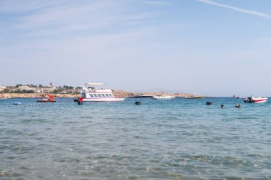 Şarm El-Şeyh, Mısır-11 Kasım 2017: Sharm El-Sheikh, Egypt 'te Naama Körfezi Denizi Plajı. İnsanlar yıkanmak, dinlenmek. Tekneler denizde yelken.