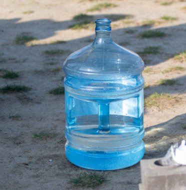 Plastic bottle for 20 liters of water on the street. clipart