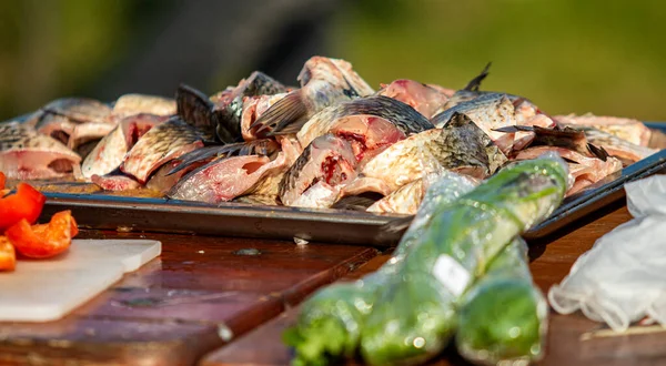 On the table, clean the fish from the scales and remove the entrails. Peeling and fillet of fresh fish that use a knife to clean the fish. Seafood cooking.