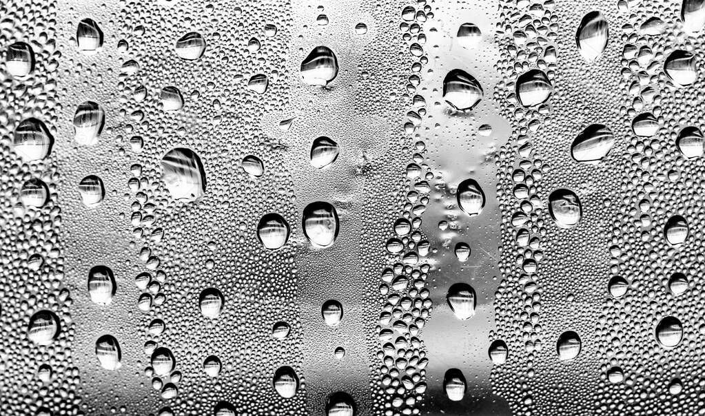 Raindrops on the glass, black-white background, fashion glass texture.