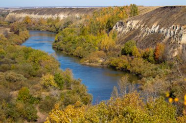 Sonbahar manzarası, sarı ağaçlar, ölü çimenler, mavi nehir. Güneşli bir sonbahar günü.