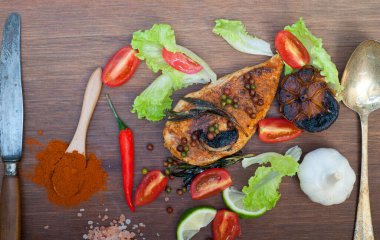 Ahşap kovuk ahşap güvertede tavuk göğsü pişirdi baharatlar ve sebzelerle.