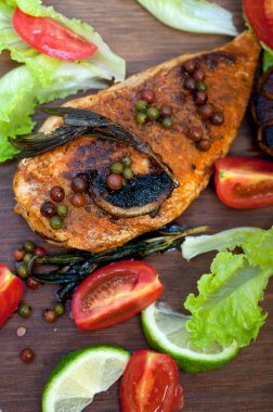 Ahşap kovuk ahşap güvertede tavuk göğsü pişirdi baharatlar ve sebzelerle.