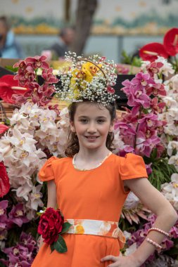 Funchal; Madeira; Portekiz - 22 Nisan; 2018: parade, Madeira çiçek Festivali, Funchal, Madeira, Portekiz, Turuncu elbiseli kız son anlarıyla