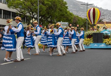 Funchal; Madeira; Portekiz - 22 Nisan; 2018: bir grup insan renkli kostümleri dans Madeira çiçek Festivali geçit töreninde Funchal, Madeira Adası üzerinde. Portekiz.