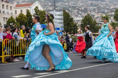 Funchal; Madeira; Portekiz - 22 Nisan; 2018: bir grup insan renkli kostümleri dans Madeira çiçek Festivali geçit töreninde Funchal, Madeira Adası üzerinde. Portekiz.