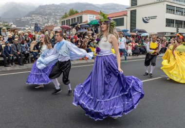 Funchal; Madeira; Portekiz - 22 Nisan; 2018: bir grup insan renkli kostümleri dans Madeira çiçek Festivali geçit töreninde Funchal, Madeira Adası üzerinde. Portekiz.