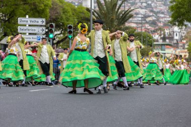 Funchal; Madeira; Portekiz - 22 Nisan; 2018: bir grup insan ayçiçeği motifli renkli elbiseler dans Madeira çiçek Festivali geçit töreninde Funchal, Madeira Adası üzerinde. Portekiz.