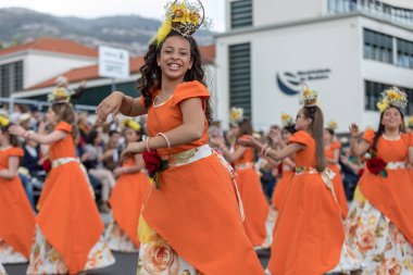 Funchal; Madeira; Portekiz - 22 Nisan; 2018: Turuncu kostümleri kız bir grup dans Madeira çiçek Festivali geçit töreninde Funchal, Madeira Adası üzerinde. Portekiz.
