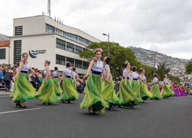 Funchal; Madeira; Portekiz - 22 Nisan; 2018: bir grup kadın renkli kostümleri dans Madeira çiçek Festivali geçit töreninde Funchal, Madeira Adası üzerinde. Portekiz.