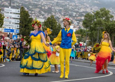 Funchal; Madeira; Portekiz - 22 Nisan; 2018: bir grup insan renkli kostümleri dans Madeira çiçek Festivali geçit töreninde Funchal, Madeira Adası üzerinde. Portekiz.