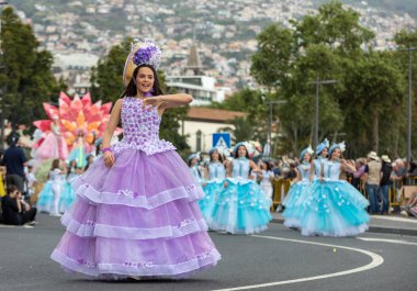 Funchal; Madeira; Portekiz - 22 Nisan; 2018: bir grup kadın renkli kostümleri dans Madeira çiçek Festivali geçit töreninde Funchal, Madeira Adası üzerinde. Portekiz.