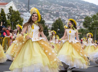 Funchal; Madeira; Portekiz - 22 Nisan; 2018: bir grup kadın sarı kostümleri dans Madeira çiçek Festivali geçit töreninde Funchal, Madeira Adası üzerinde. Portekiz.