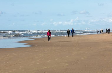 Katwijk, Hollanda - 23 Nisan 2017: Güneşli bir günde Katwijk plaj boyunca insanlar yürüyor. Hollanda