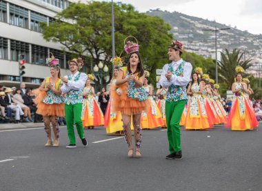 Funchal; Madeira; Portekiz - 22 Nisan; 2018: bir grup insan renkli kostümleri dans Madeira çiçek Festivali geçit töreninde Funchal, Madeira Adası üzerinde. Portekiz.