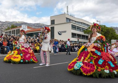 Funchal; Madeira; Portekiz - 22 Nisan; 2018: bir grup insan renkli kostümleri dans Madeira çiçek Festivali geçit töreninde Funchal, Madeira Adası üzerinde. Portekiz.