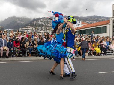 Funchal; Madeira; Portekiz - 22 Nisan; 2018: bir grup insan renkli kostümleri dans Madeira çiçek Festivali geçit töreninde Funchal, Madeira Adası üzerinde. Portekiz.