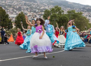 Funchal; Madeira; Portekiz - 22 Nisan; 2018: bir grup insan renkli kostümleri dans Madeira çiçek Festivali geçit töreninde Funchal, Madeira Adası üzerinde. Portekiz.