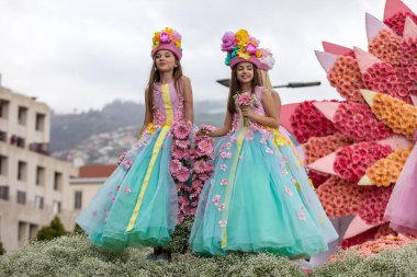 Funchal; Madeira; Portekiz - 22 Nisan; 2018: kızlar çiçek float Madeira çiçek Festivali geçit töreninde Funchal Madeira Adası, üzerinde renkli kostümleri. Portekiz.