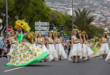 Funchal; Madeira; Portekiz - 22 Nisan; 2018: bir grup kadın ayçiçeği motifli renkli elbiseler dans Madeira çiçek Festivali geçit töreninde Funchal, Madeira Adası üzerinde. Portekiz.