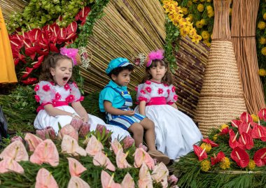 Funchal; Madeira; Portekiz - 22 Nisan; 2018: Madeira çiçek Festivali geçit töreninde Funchal Madeira Adası, çiçek kayan nokta üzerinde renkli kostümleri çocuklar. Portekiz.
