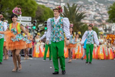 Funchal; Madeira; Portekiz - 22 Nisan; 2018: bir grup insan renkli kostümleri dans Madeira çiçek Festivali geçit töreninde Funchal, Madeira Adası üzerinde. Portekiz.