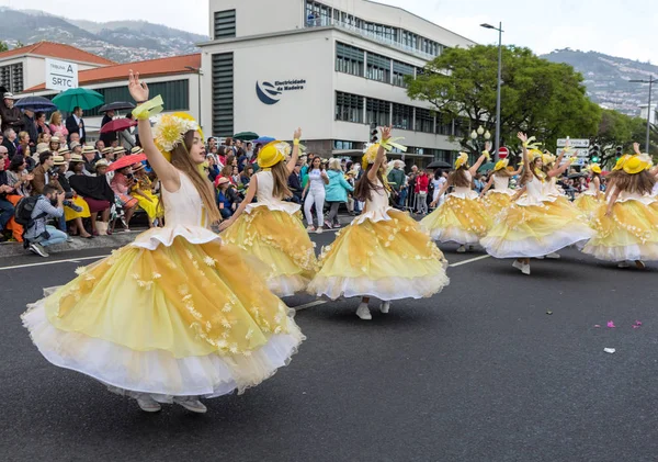 Funchal; Madeira; Portekiz - 22 Nisan; 2018: bir grup kadın sarı kostümleri dans Madeira çiçek Festivali geçit töreninde Funchal, Madeira Adası üzerinde. Portekiz.