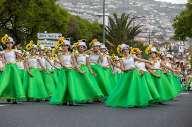 Funchal; Madeira; Portekiz - 22 Nisan; 2018: ayçiçeği motifli renkli elbiseler kız bir grup dans Madeira çiçek Festivali geçit töreninde Funchal, Madeira Adası üzerinde. Portekiz.