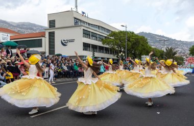 Funchal; Madeira; Portekiz - 22 Nisan; 2018: bir grup kadın sarı kostümleri dans Madeira çiçek Festivali geçit töreninde Funchal, Madeira Adası üzerinde. Portekiz.
