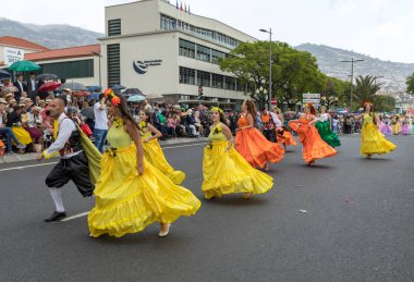 Funchal; Madeira; Portekiz - 22 Nisan; 2018: bir grup insan renkli kostümleri dans Madeira çiçek Festivali geçit töreninde Funchal, Madeira Adası üzerinde. Portekiz.