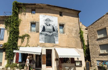 Gordes, Fransa - 25 Haziran 2017: Tipik eski bir taş ev Gordes Köyü, Vaucluse, Provence, Fransa eski moda yaşam sahneleri tasvir bir pano ile