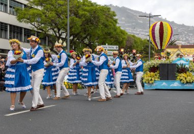 Funchal; Madeira; Portekiz - 22 Nisan; 2018: bir grup insan renkli kostümleri dans Madeira çiçek Festivali geçit töreninde Funchal, Madeira Adası üzerinde. Portekiz.