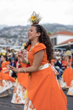 Funchal; Madeira; Portekiz - 22 Nisan; 2018: Turuncu kostümleri kız bir grup dans Madeira çiçek Festivali geçit töreninde Funchal, Madeira Adası üzerinde. Portekiz.