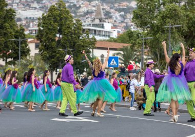 Funchal; Madeira; Portekiz - 22 Nisan; 2018: bir grup insan renkli kostümleri dans Madeira çiçek Festivali geçit töreninde Funchal, Madeira Adası üzerinde. Portekiz.