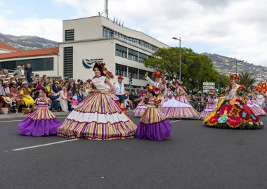 Funchal; Madeira; Portekiz - 22 Nisan; 2018: bir grup insan renkli kostümleri dans Madeira çiçek Festivali geçit töreninde Funchal, Madeira Adası üzerinde. Portekiz.