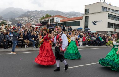 Funchal; Madeira; Portekiz - 22 Nisan; 2018: bir grup insan renkli kostümleri dans Madeira çiçek Festivali geçit töreninde Funchal, Madeira Adası üzerinde. Portekiz.
