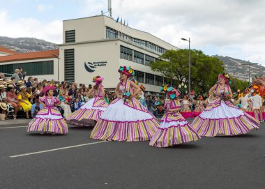 Funchal; Madeira; Portekiz - 22 Nisan; 2018: bir grup kadın renkli kostümleri dans Madeira çiçek Festivali geçit töreninde Funchal, Madeira Adası üzerinde. Portekiz.