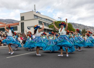 Funchal; Madeira; Portekiz - 22 Nisan; 2018: bir grup kadın renkli kostümleri dans Madeira çiçek Festivali geçit töreninde Funchal, Madeira Adası üzerinde. Portekiz.