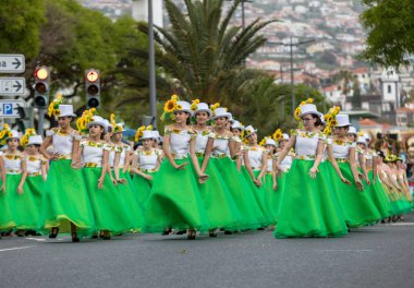Funchal; Madeira; Portekiz - 22 Nisan; 2018: ayçiçeği motifli renkli elbiseler kız bir grup dans Madeira çiçek Festivali geçit töreninde Funchal, Madeira Adası üzerinde. Portekiz.