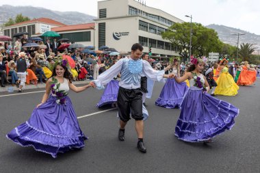 Funchal; Madeira; Portekiz - 22 Nisan; 2018: bir grup insan renkli kostümleri dans Madeira çiçek Festivali geçit töreninde Funchal, Madeira Adası üzerinde. Portekiz.