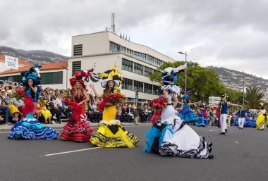 Funchal; Madeira; Portekiz - 22 Nisan; 2018: bir grup insan renkli kostümleri dans Madeira çiçek Festivali geçit töreninde Funchal, Madeira Adası üzerinde. Portekiz.