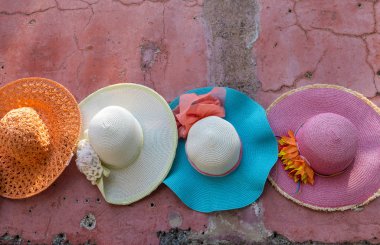 Pembe duvarda asılı renkli şapkalar