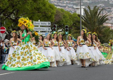 Funchal; Madeira; Portekiz - 22 Nisan; 2018: bir grup kadın ayçiçeği motifli renkli elbiseler dans Madeira çiçek Festivali geçit töreninde Funchal, Madeira Adası üzerinde. Portekiz.