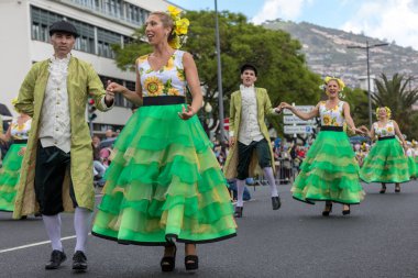 Funchal; Madeira; Portekiz - 22 Nisan; 2018: bir grup insan ayçiçeği motifli renkli elbiseler dans Madeira çiçek Festivali geçit töreninde Funchal, Madeira Adası üzerinde. Portekiz.