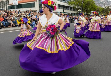 Funchal; Madeira; Portekiz - 22 Nisan; 2018: bir grup insan renkli kostümleri dans Madeira çiçek Festivali geçit töreninde Funchal, Madeira Adası üzerinde. Portekiz.